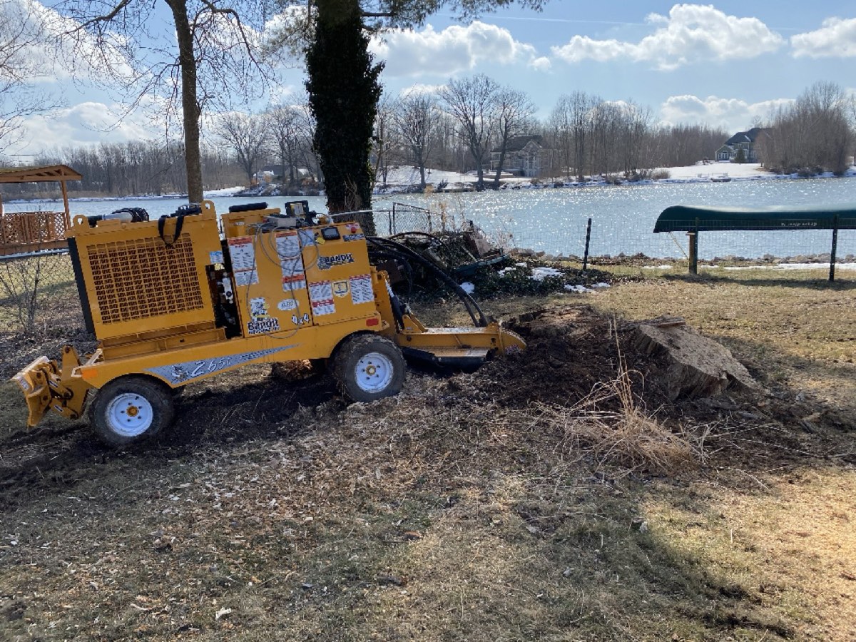 The self-propelled Bandit stump grinder beside a lakeside property