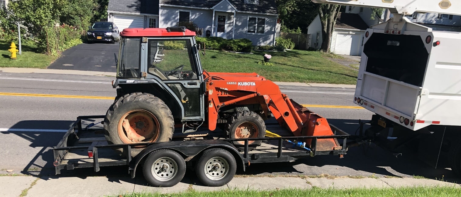 Kubota tractor and bucket truck loaded for a job